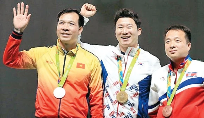 Hoàng Xuân Vinh (bên trái) trên bục nhận huy chương.
