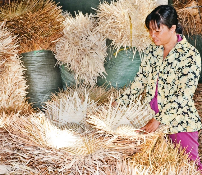 Chị TrầnThị Thiền giúp nhiều chị em có thêm thu nhập từ nghề đan nón bàng.