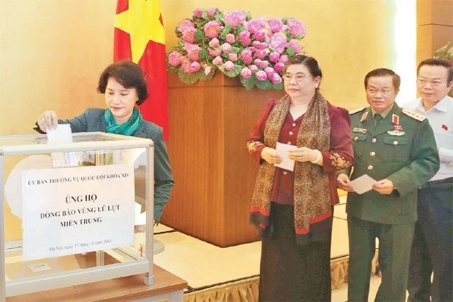 Chủ tịch QH Nguyễn Thị Kim Ngân và các đại biểu quyên góp ủng hộ đồng bào miền trung. Ảnh: PHƯƠNG HOA (TTXVN)
