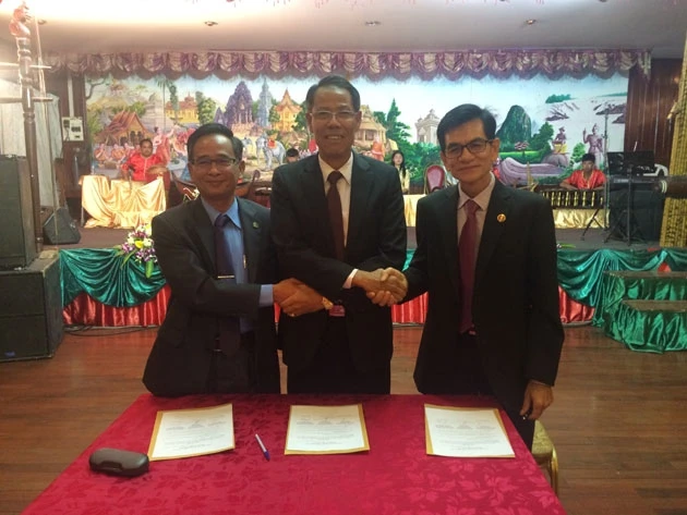 Đại diện ba Tổng hội người Việt Nam tại Lào (giữa), Thái-lan và Cam-pu-chia tại Lễ ký bản ghi nhớ hợp tác.