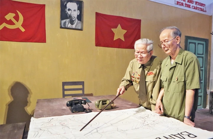 Ông Phùng Đệ (bên trái), chiến sĩ Trung đoàn Thủ đô năm xưa ôn lại kỷ niệm với người bạn già. Ảnh: Như Ý