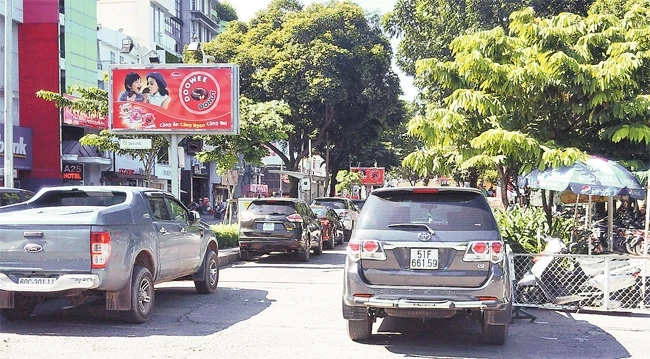 Nhiều phương tiện không có chỗ đỗ xe đã đỗ tràn ra trước cửa Công viên Lê Văn Tám (quận 1, TP Hồ Chí Minh).