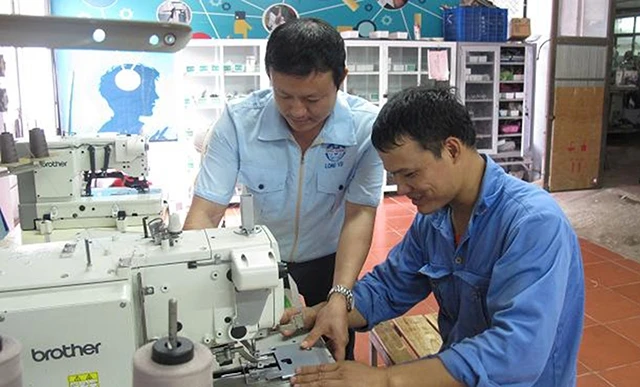 Đảng viên Nguyễn Xuân Điệp (người bên trái), Bí thư chi bộ, Tổ trưởng cơ điện thuộc Tổng Công ty May Bắc Giang, có nhiều sáng kiến trong lao động sản xuất, là tấm gương điển hình của tỉnh Bắc Giang tr