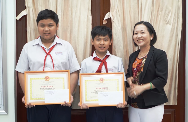 Phó Chủ tịch UBND thành phố Thủ Dầu Một Nguyễn Thu Cúc trao Giấy khen cho hai cháu. 