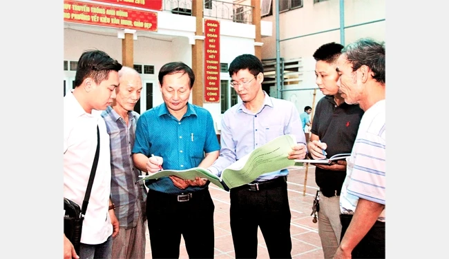 Cán bộ MTTQ phường Yết Kiêu, quận Hà Đông (Hà Nội) trao đổi, giám sát công việc cải tạo một công trình văn hóa. Ảnh: BÁ HOẠT