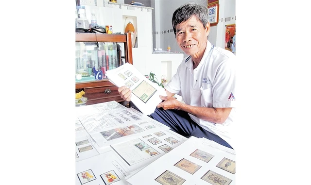 Ông Trần Hữu Huệ bên bộ sưu tập tem với chuyên đề "Việt Nam, dân tộc anh hùng". Ảnh: THANH DŨNG