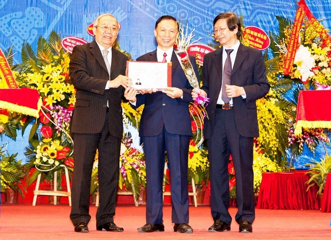 GS, TSKH Trần Văn Nhung, Tổng Thư ký Hội đồng Chức danh Giáo sư Nhà nước (người đứng ở bên trái) trao Quyết định công nhận Phó Giáo sư. Ảnh: ĐỨC KIM