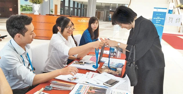 Các tình nguyện viên đón tiếp và hỗ trợ các đại biểu APEC tại Trung tâm Hội nghị quốc gia.