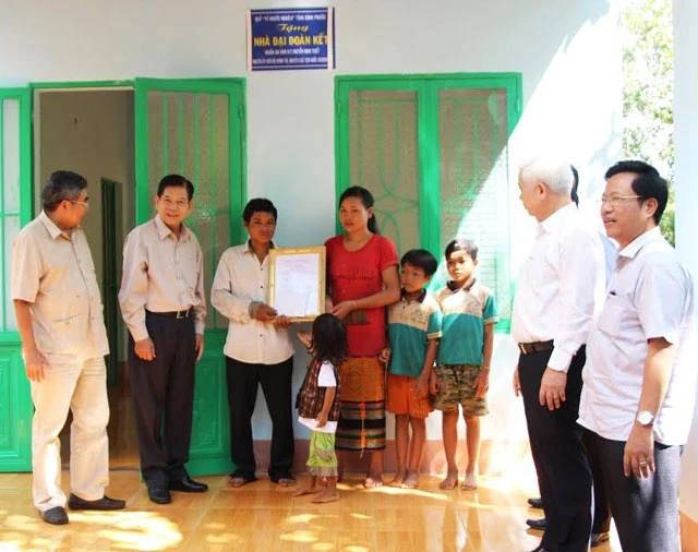 Nguyên Chủ tịch nước Nguyễn Minh Triết (thứ hai từ trái qua) tặng nhà đại đoàn kết cho gia đình anh Điểu Hùng.