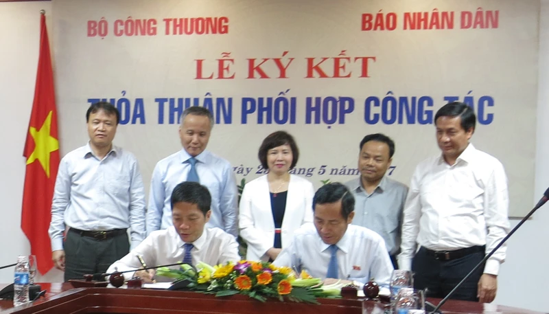 Tổng Biên tập Báo Nhân Dân Thuận Hữu và Bộ trưởng Công thương Trần Tuấn Anh ký thỏa thuận phối hợp công tác giữa hai cơ quan.