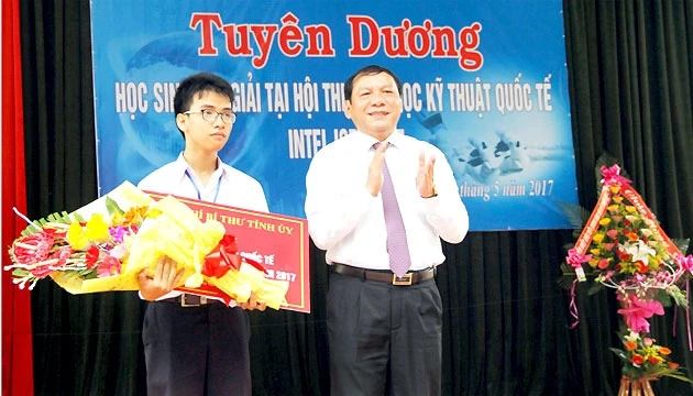 Đồng chí Nguyễn Văn Hùng, Ủy viên T.Ư Đảng, Bí thư Tỉnh ủy Quảng Trị tặng hoa và phần thưởng cho em Phạm Huy.