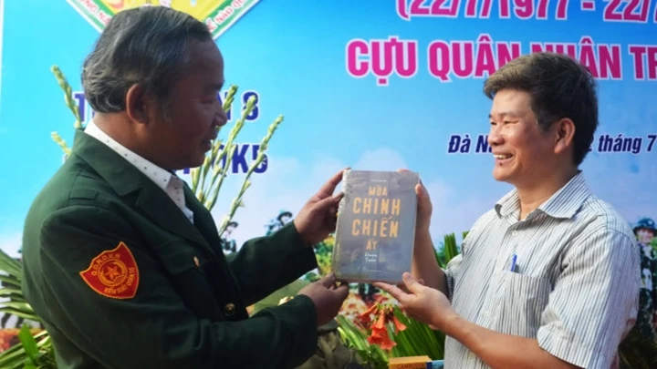 Tác giả Đoàn Tuấn (bên phải) tặng sách cho đồng đội. Ảnh: ĐOÀN NHẠN