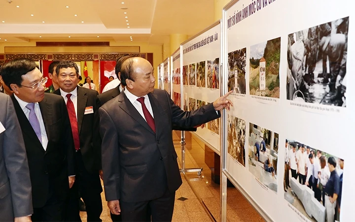 Thủ tướng Nguyễn Xuân Phúc xem một số hình ảnh về khu vực biên giới và các sự kiện đàm phán về biên giới Việt Nam - Lào. Ảnh: THỐNG NHẤT (TTXVN)