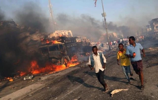 Người dân sơ tán khỏi hiện trường vụ đánh bom tại đường KM4, quận Hodan, Mogadishu, Somalia, ngày 14-10. (Ảnh: Reuters)