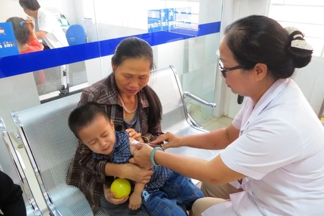 Người dân TP Buôn Ma Thuột đưa con em đến Trung tâm Y tế dự phòng tỉnh tiêm vắc-xin phòng chống viêm não Nhật Bản.