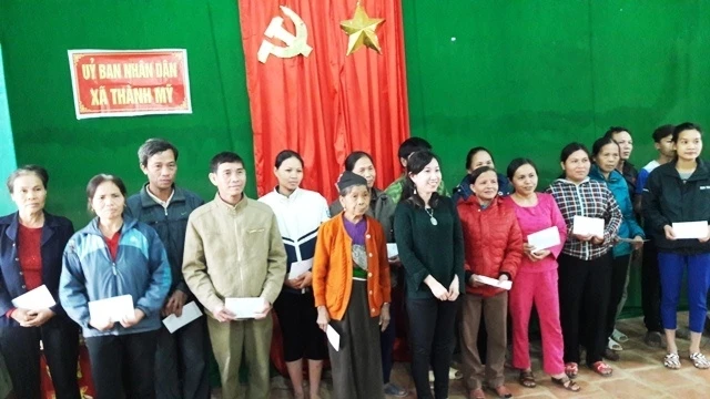 Bà Thanh Hằng, Phó Chủ tịch Hội người Việt Nam tại Pháp trao quà cho các hộ nghèo bị ngập lũ.