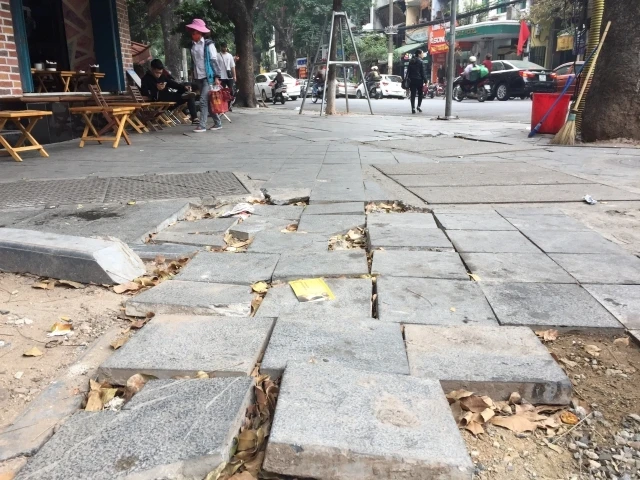 Vỉa hè bong tróc, hư hỏng trên phố Nguyễn Hữu Huân, Hoàn Kiếm. (Ảnh: Đăng Anh)