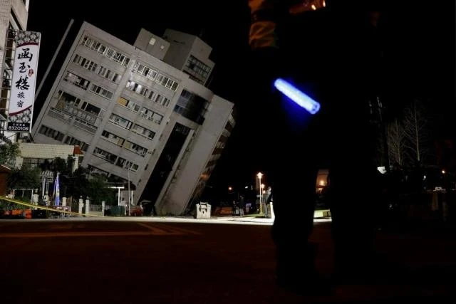 Cảnh sát phong tỏa tòa nhà bị nghiêng do động đất để phục vụ công tác cứu nạn. (Ảnh: Reuters)