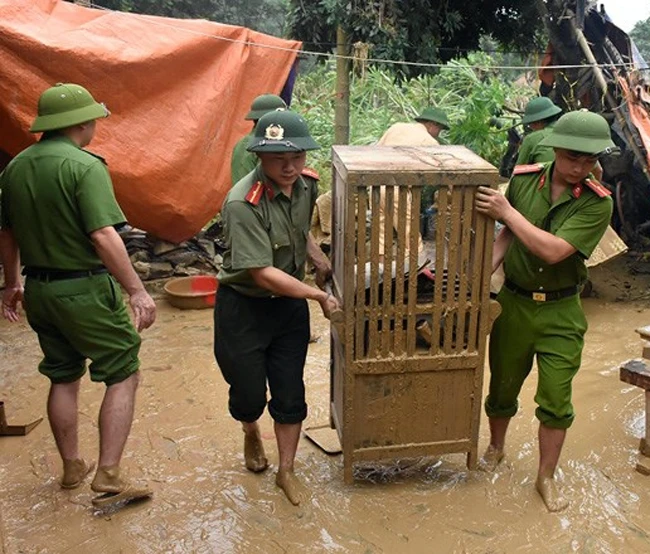 Cán bộ, chiến sĩ Công an huyện Thường Xuân giúp dân sửa sang nhà cửa, dọn dẹp vệ sinh sau lũ.