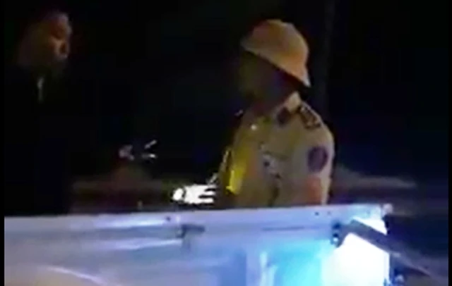 Trung tá Bùi Minh Hưng dùng đèn pin chiều về người quay phim. (Ảnh cắt từ video clip) 