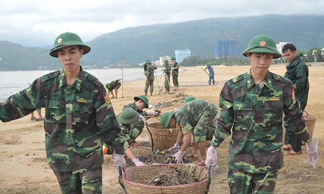 Bộ đội Biên phòng tỉnh Bình Định giúp dân khắc phục hậu quả bão lũ tại vùng biển Quy Nhơn. Ảnh: CÔNG CƯỜNG