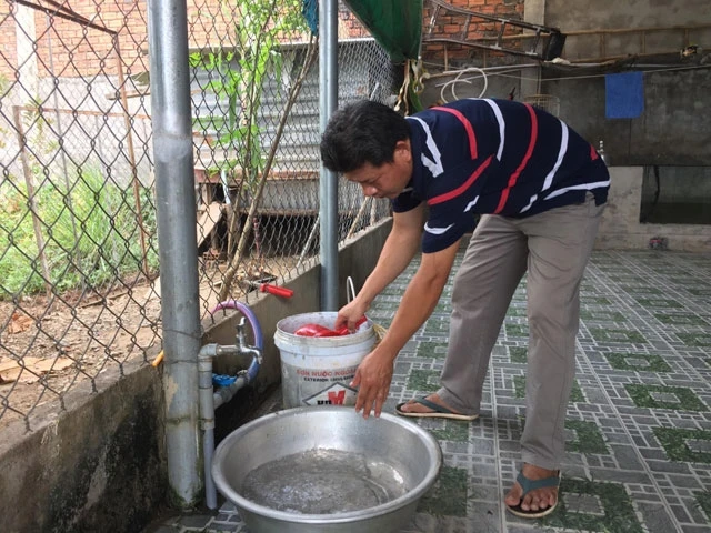 Anh Phạm Thanh Bình phải đi xin nhờ nước sinh hoạt của một hộ dân khác để sử dụng khi hệ thống nước của gia đình bị cắt.
