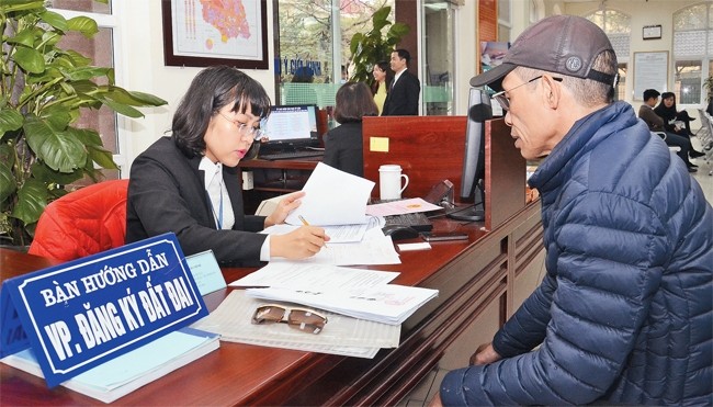 Hướng dẫn người dân hoàn thiện hồ sơ cấp giấy chứng nhận quyền sử dụng đất tại Văn phòng đăng ký đất đai Hà Nội - chi nhánh quận Nam Từ Liêm. Ảnh: DUY LINH
