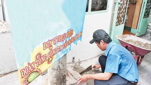 Nhân viên Công ty Cấp nước Chợ Lớn trám lấp giếng khoan trên địa bàn quận Bình Tân sau khi đã đưa nước máy đến tận hộ dân.