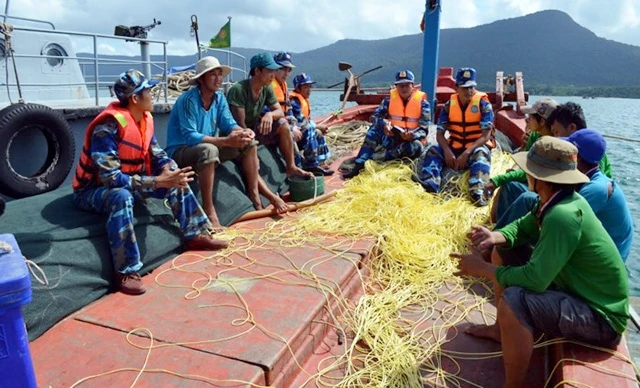 Bộ đội Biên phòng Kiên Giang tuyên truyền đến ngư dân những quy định của Nhà nước về khai thác, đánh bắt hải sản trên biển. Ảnh: LÊ SEN