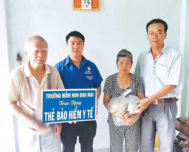 Anh Nguyễn Văn Thương (ngoài cùng bên phải) trao quà tặng người nghèo ở địa phương.
