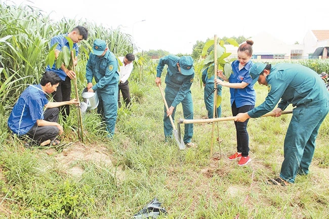 Dân quân tự vệ và đoàn viên thanh niên huyện Củ Chi ra quân trồng cây xanh góp phần bảo vệ môi trường.