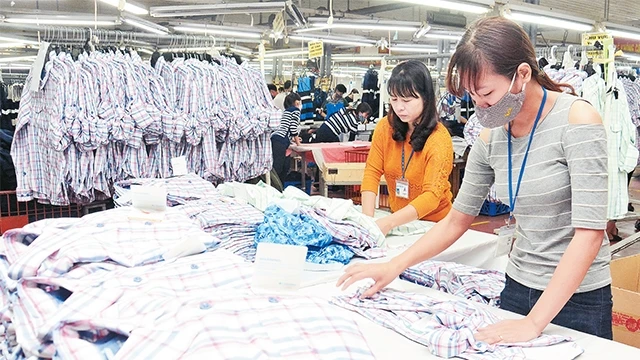 Công nhân Công ty CP May Sơn Hà kiểm tra chất lượng sản phẩm áo sơ-mi. Ảnh: ÐĂNG ANH