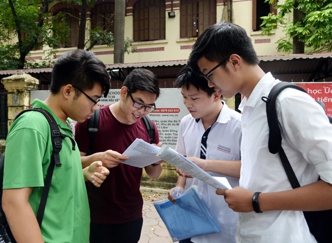 Các thí sinh trao đổi bài thi môn Sinh học (môn cuối trong bài thi tổ hợp KHTN) tại điểm thi Trường THPT Trần Phú (Hà Nội). Ảnh: THỦY MAI