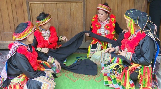 Phụ nữ dân tộc Dao đỏ thôn Bản Cuôn 2, xã Ngọc Phái, huyện Chợ Đồn trao đổi kỹ thuật trang trí hoa văn trên vải chàm.