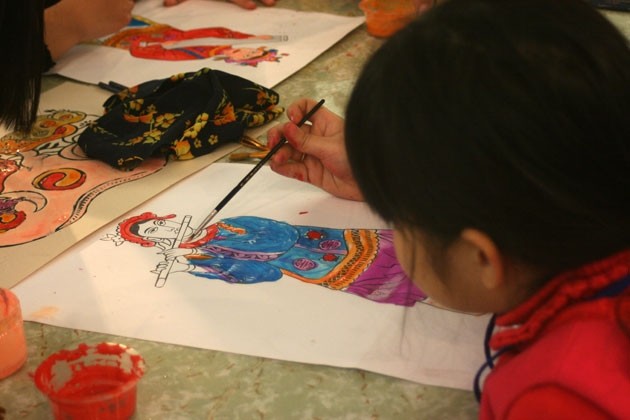 Trẻ em tập vẽ tranh Đông Hồ dịp tết Nguyên đán.
