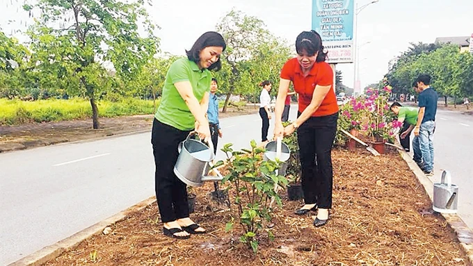 Hội viên Hội Liên hiệp Phụ nữ và Ðoàn Thanh niên quận Long Biên tham gia làm đẹp môi trường.