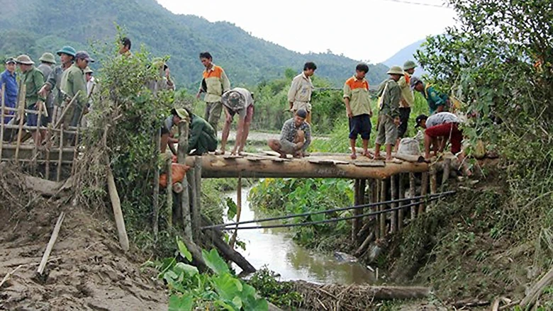Cây cầu bắc qua mương được người dân bản Ðỏn Chám, xã Mường Nọc, huyện Quế Phong, tỉnh Nghệ An dựng tạm sau mưa lũ. Ảnh: HỒ PHƯƠNG