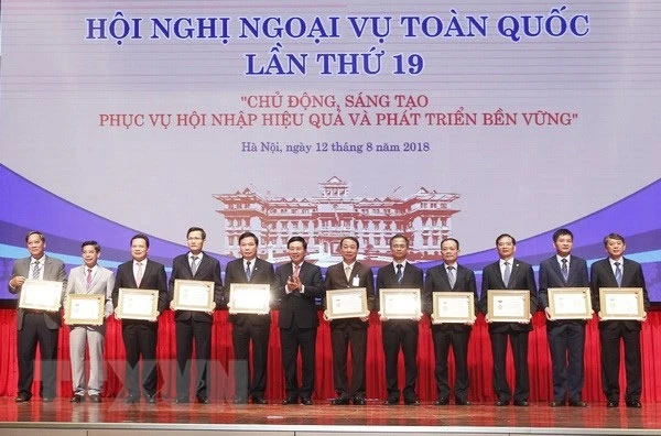 Phó Thủ tướng, Bộ trưởng Bộ Ngoại giao Phạm Bình Minh trao Kỷ niệm chương Vì sự nghiệp Ngoại giao Việt Nam cho các lãnh đạo tỉnh, thành phố. Ảnh: TTXVN