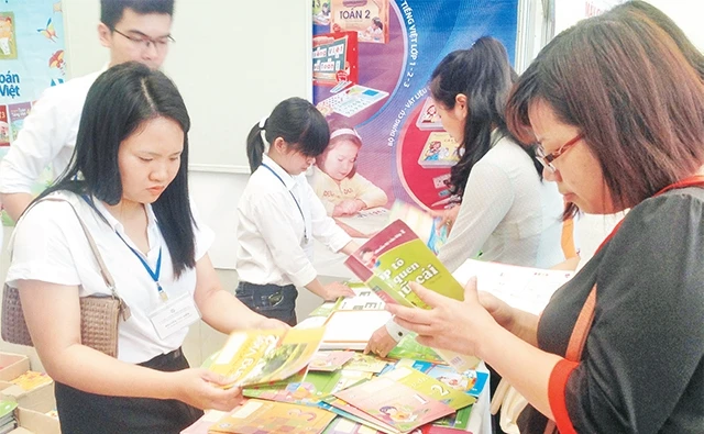 Phụ huynh học sinh tìm mua sách giáo khoa tại cửa hàng sách và đồ dùng học tập.