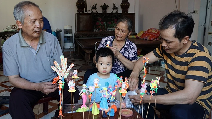 NNƯT Nguyễn Văn Thành (ngoài cùng bên phải) tiếp nối truyền thống gia đình, nỗ lực phát triển nghề nặn tò he (làng Xuân La, Phú Xuyên, Hà Nội).