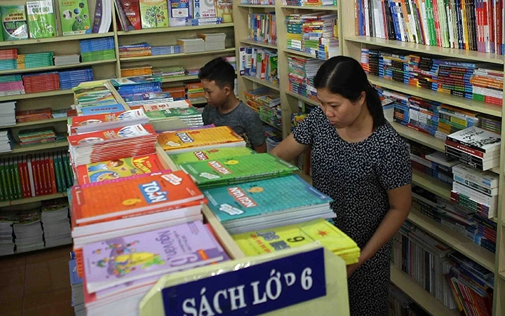 Phụ huynh, học sinh tìm mua SGK tại một cửa hàng sách giáo dục trên đường Giảng Võ (Hà Nội).