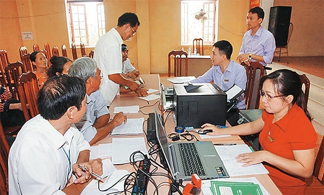 Cán bộ Ngân hàng Chính sách xã hội Hà Nội hướng dẫn hộ nghèo huyện Phúc Thọ làm thủ tục vay vốn đầu tư sản xuất và xây dựng, sửa chữa nhà ở. Ảnh: THÁI HIỀN