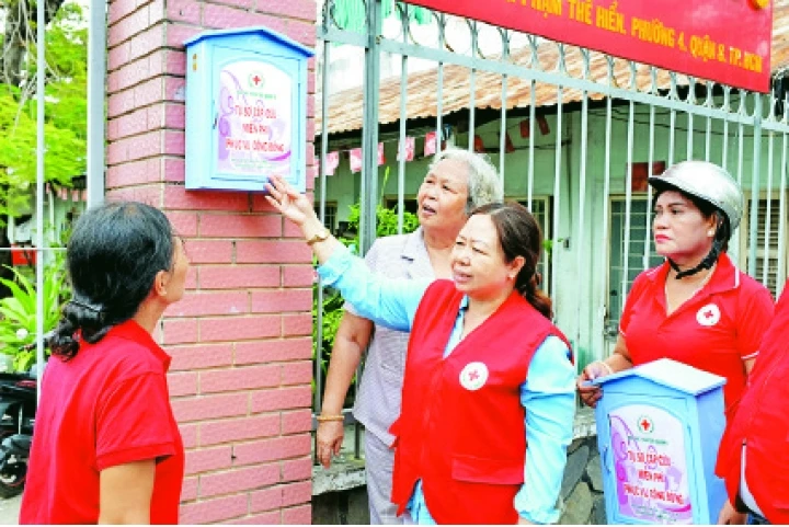 Đại diện Hội Chữ thập đỏ quận 8 hướng dẫn người dân cách sử dụng tủ sơ cấp cứu cộng đồng.