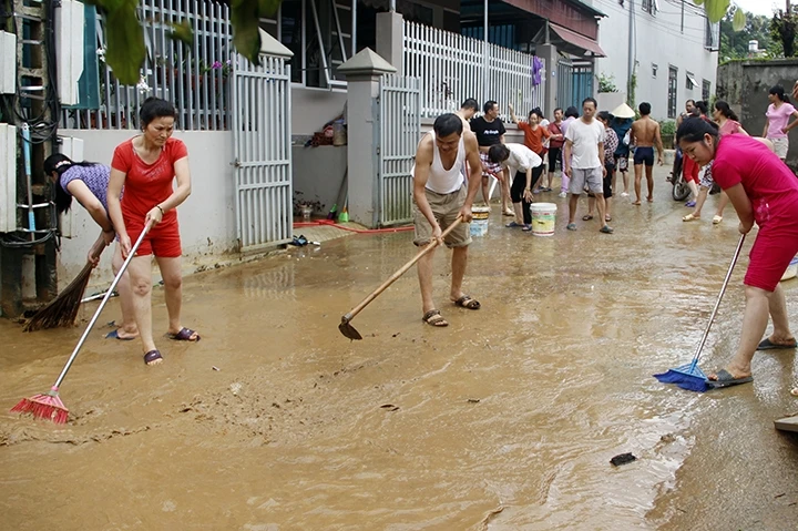 Người dân tiểu khu 8, thị trấn Hát Lót (huyện Mai Sơn) dọn vệ sinh sau lũ.