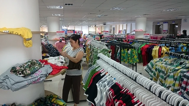 Người tiêu dùng lựa chọn sản phẩm may mặc tại Trung tâm thời trang Vinatex trên phố Bà Triệu (Hà Nội).