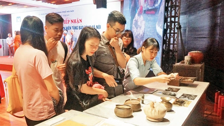 Giới trẻ đến tìm hiểu những hiện vật được hiến tặng cho Bảo tàng Hà Nội.