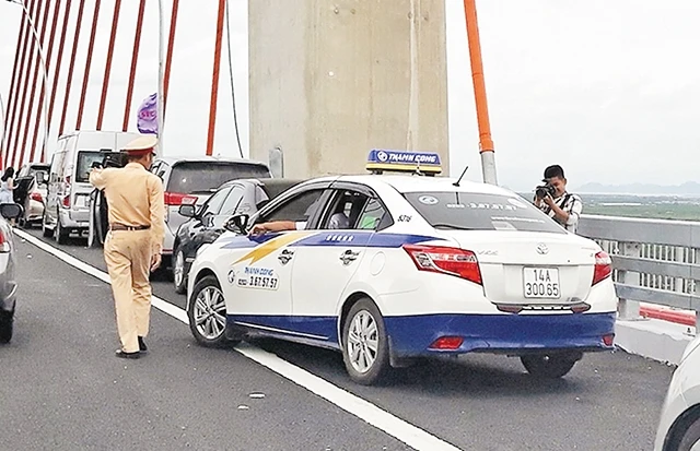Lực lượng CSGT đã phải làm việc rất vất vả nhưng tình trạng dừng, đỗ xe trên cầu Bạch Đằng vẫn không giảm.