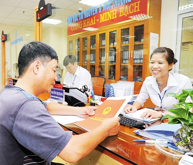 Cán bộ Bộ phận một cửa UBND quận Hoàn Kiếm (Hà Nội) giải quyết thủ tục hành chính cho người dân. Ảnh | Đức Anh