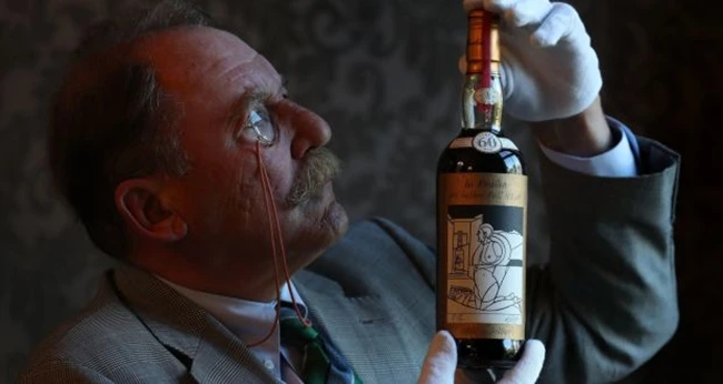 Một chuyên gia về rượu whisky đang nâng niu chai rượu Macallan Valerio Adami 1926 trên tay. Ảnh: The Irish Times