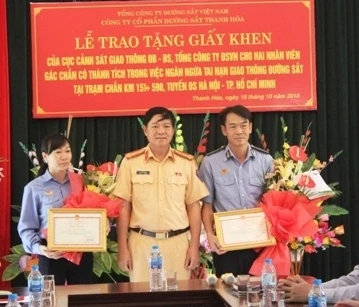 Đại diện Cục Cảnh sát giao thông trao giấy khen cho hai nhân viên Công ty Cổ phần Đường sắt Thanh Hóa.